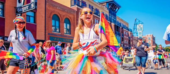 Image of a kid and adult at an LGBT Pride Parade in Fargo
